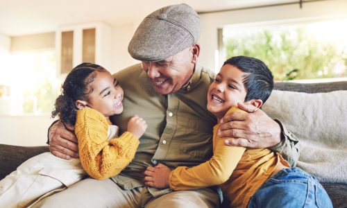 hug, grandfather or happy children in family home on sofa with love enjoying quality bonding time together. smile, affection or senior grandparent relaxing with young kids or siblings on house couch